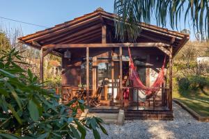 a small cabin with a hammock in front of it at Vale da Silva Villas - Homes in Albergaria-a-Velha