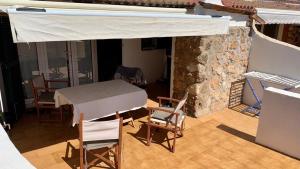 a room with a table and chairs and a stone wall at Villas Estrellas 11 in Ciutadella