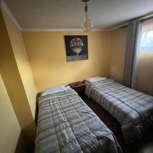 Habitación de hotel con 2 camas y ventana en alojamiento diario con baño compartido, en Calama