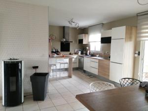 a kitchen with white cabinets and a table and chairs at La conviviale in Saintes
