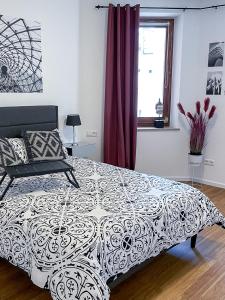 Schlafzimmer mit einem schwarzen und weißen Bett und einem Fenster in der Unterkunft Velvet ein Haus mit Geschichte im Herzen Tettnangs Messe Friedrichshafen in Tettnang