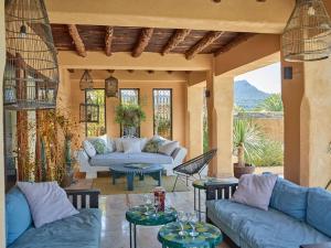 a living room with blue couches and tables at Kasbah 1 in Cala Vadella