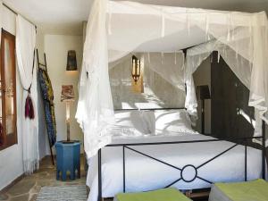 1 dormitorio con 1 cama blanca con dosel en Kasbah 1, en Cala Vadella