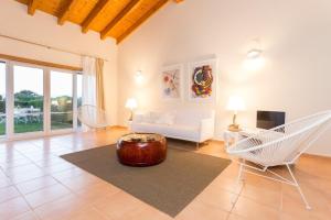 a living room with a couch and a table and chairs at Villas T3 com Jardim Vila Sagres in Sagres