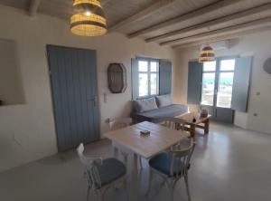 ein Wohnzimmer mit einem Tisch, Stühlen und einem Sofa in der Unterkunft Mosaic Suites in Drios