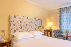 a bedroom with a bed and a blue chair at Kouneni Apartments in Mikonos