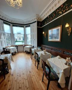 a dining room with tables and chairs and windows at Barony House in Edinburgh