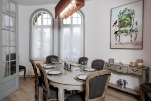 a dining room with a white table and chairs at La Perle des Isles**** - Nouvelle création des Suites Mana in Rethel