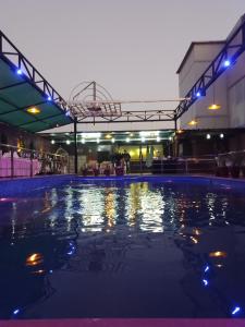 een zwembad 's nachts met lichten aan bij Hotel 5 Flowers Ananta Elite in Kota