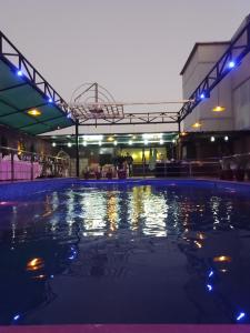 a swimming pool at night with lights on at Hotel 5 Flowers Ananta Elite in Kota