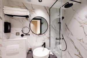 W łazience znajduje się umywalka i lustro. w obiekcie Star Champs-Elysées w Paryżu
