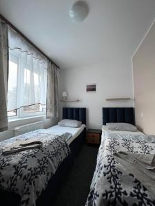 two beds in a room with a window at Ośrodek Wczasowy Camping Morski in Ustka