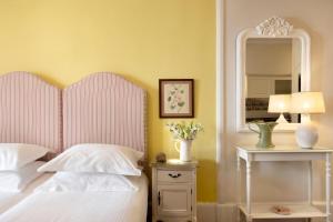 sypialnia z białym łóżkiem i lustrem w obiekcie Kouneni Apartments w mieście Mykonos