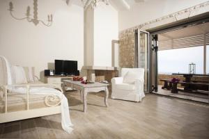 a living room with a bed and a couch and a table at Poliana Estate Villas in Riglia