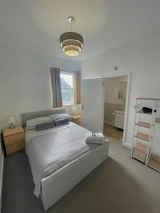 een slaapkamer met een groot bed en een licht bij La Fontaine Court Apartments - Aldershot in Aldershot