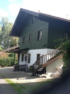 Casa verde y blanca con escalera de madera en Ferienwohnung Moosegger, en Bad Feilnbach