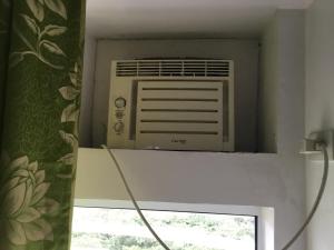 um ar condicionado sentado numa parede ao lado de uma janela em Condo with Free Swimming Pool & Viewing Deck em Tagaytay