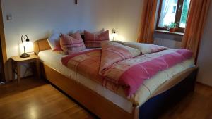 1 cama en un dormitorio con 2 lámparas en una mesa en Ferienwohnung Moosegger, en Bad Feilnbach