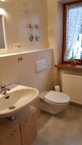 a white bathroom with a sink and a toilet at Ferienwohnung Moosegger in Bad Feilnbach +20 photos
