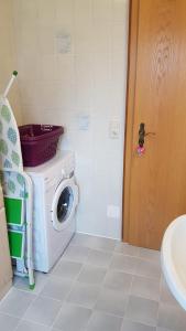 un baño junto a una puerta con lavadora en Ferienwohnung Moosegger, en Bad Feilnbach