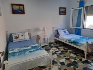 a room with two beds and a table and a window at "Gorgones" Mermaids Place in Kalymnos