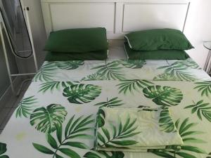 - une chambre avec 2 lits avec des feuilles vertes dans l'établissement Condo with Free Swimming Pool & Viewing Deck, à Tagaytay