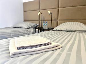 een stapel handdoeken bovenop een bed bij Apartament RadMila2 Premium in Radom