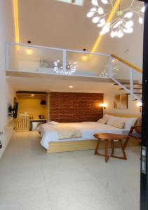a bedroom with a large white bed and a staircase at GSV Cottage Sharia in Bogor