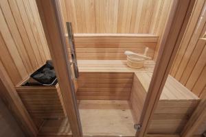 a small wooden sauna with a door open at Kostovac Boutique Homes - Apartment with Sauna in Kopaonik