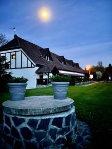 una casa con dos ollas grandes delante de ella en Hotel Jiřičná, en Sušice