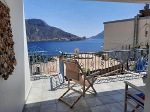 una silla en el balcón con vistas al agua en "Gorgones" Mermaids Place en Kalymnos