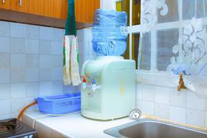 a kitchen counter with a blue bottle on top of a sink at Lux Suites L&N Apartments Utawala in Embakasi +46 photos