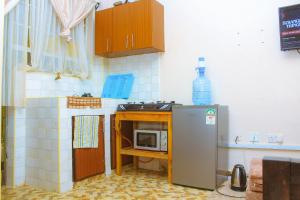 a small kitchen with a microwave on a counter at Lux Suites L&N Apartments Utawala in Embakasi