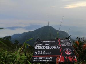 a sign on the side of a mountain with mountains in the background at Maju Homestay in Gerik