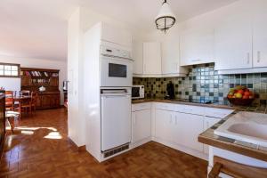 uma cozinha com armários brancos e um frigorífico branco em Micaes - maison avec piscine privée em Roquebrune-sur-Argens