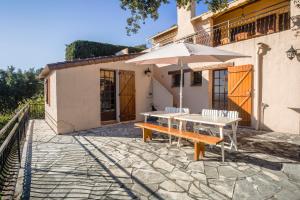 um pátio com uma mesa e um guarda-chuva em Micaes - maison avec piscine privée em Roquebrune-sur-Argens