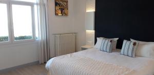 - une chambre avec un lit blanc et un mur noir dans l'établissement Hotel Uhainak, à Hendaye