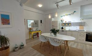 eine Küche mit einem Tisch und Stühlen im Zimmer in der Unterkunft AAY- Best Corfu Town & Sea Apart 2bedroom Renovated + lift / Comfy&Design+WiFi in Korfu-Stadt