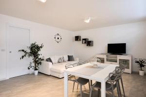 uma sala de estar branca com uma mesa branca e um sofá branco em Corallo House Alghero em Alghero