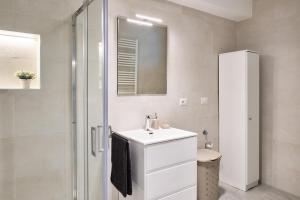 ein weißes Bad mit einem Waschbecken und einer Dusche in der Unterkunft Corallo House Alghero in Alghero
