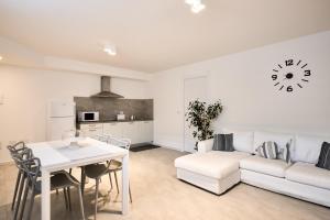 uma sala de estar com um sofá branco e uma mesa em Corallo House Alghero em Alghero