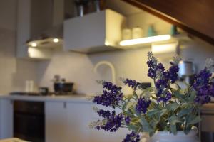 格拉多的住宿－Calilla Home - appartamento Maestrale，厨房里装满紫色花的花瓶