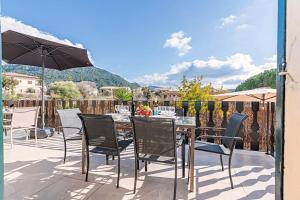 eine Terrasse mit einem Tisch, Stühlen und einem Sonnenschirm in der Unterkunft Villa PARADISE in Palma de Mallorca