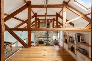 a large room with wooden beams and a vaulted ceiling at Threshing Barn at East Trenean Farm -Stunning Cornish Cottage sleeping 6 with hot tub, private garden, rural views and EV facilities in East Looe