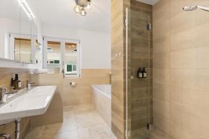 a bathroom with a tub and a sink and a shower at Casa Tegernsee - zentral, modern, Nespresso, 3 Min zum See in Gmund am Tegernsee