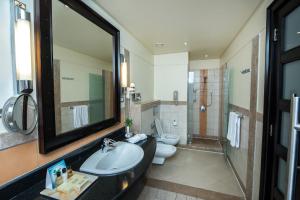 a bathroom with a sink and a toilet and a mirror at Reef Oasis Blue Bay Resort & Spa in Sharm El Sheikh