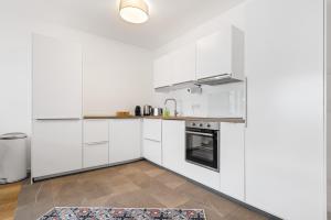 a kitchen with white cabinets and a rug at Casa Tegernsee - zentral, modern, Nespresso, 3 Min zum See in Gmund am Tegernsee