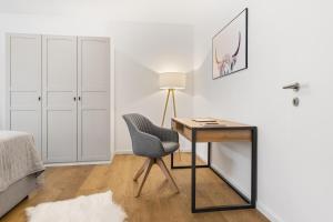 a bedroom with a desk and a chair next to a bed at Casa Tegernsee - zentral, modern, Nespresso, 3 Min zum See in Gmund am Tegernsee