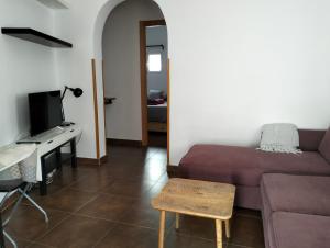 een woonkamer met een bank en een tafel bij La corrala de Malasaña in Madrid