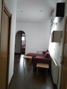 een woonkamer met een paarse bank en een tafel bij La corrala de Malasaña in Madrid